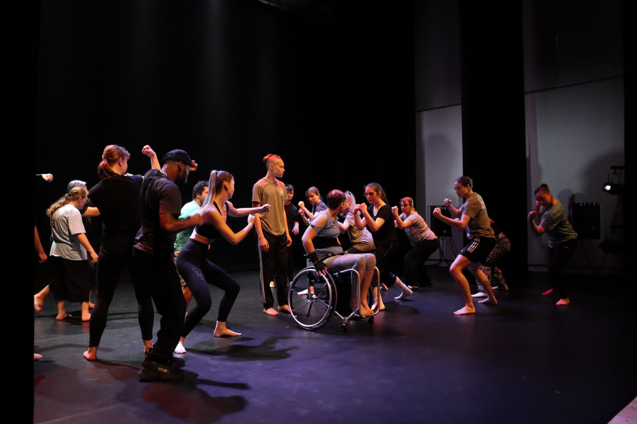 All dancers on stage facing in towards Romeo and Juliet with fists clenched. 